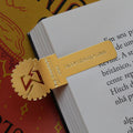 Marcador de página dourado de Engenharia da Computação encaixado em um livro